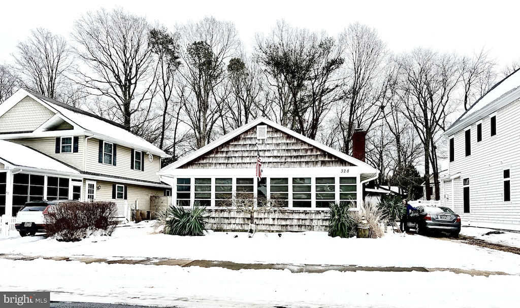 snow covered house with a sunroom