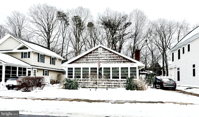 snow covered house with a sunroom