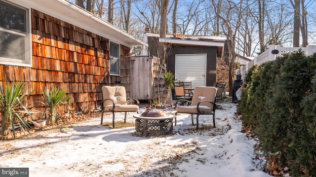 snow covered patio with a fire pit