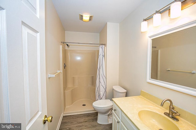 bathroom featuring wood-type flooring, toilet, vanity, and a shower with curtain