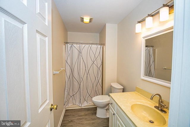 bathroom featuring hardwood / wood-style flooring, toilet, and vanity