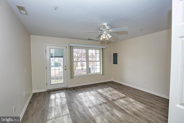 empty room with ceiling fan, electric panel, and hardwood / wood-style floors