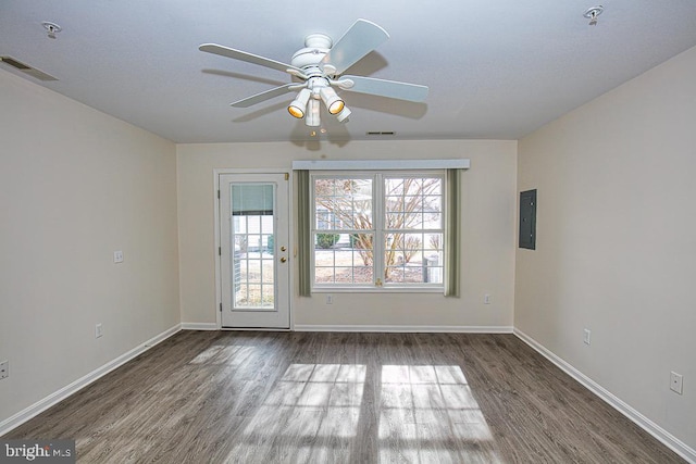 unfurnished room with electric panel and dark hardwood / wood-style flooring