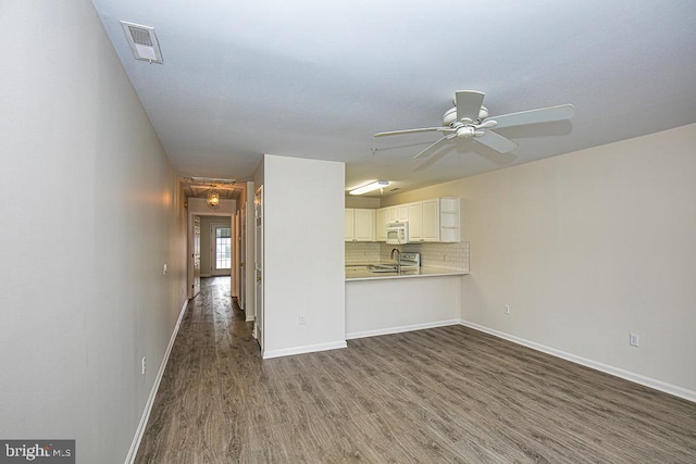 unfurnished living room featuring ceiling fan and dark hardwood / wood-style flooring