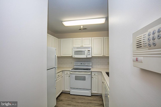 kitchen featuring decorative backsplash, white appliances, and white cabinets