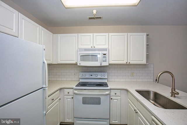 kitchen featuring sink, white appliances, white cabinets, and tasteful backsplash