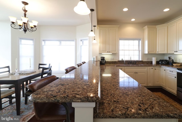148 Gemstone Dr, Bellefonte, PA 16823 - kitchen with a peninsula, a kitchen bar, recessed lighting, a sink, and an inviting chandelier