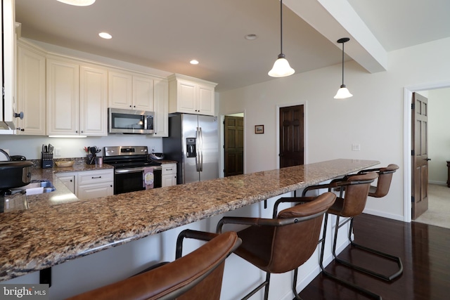 148 Gemstone Dr, Bellefonte, PA 16823 - kitchen with a peninsula, dark stone counters, recessed lighting, stainless steel appliances, and a kitchen breakfast bar