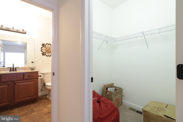148 Gemstone Dr, Bellefonte, PA 16823 - bathroom with visible vents, baseboards, toilet, vanity, and a walk in closet
