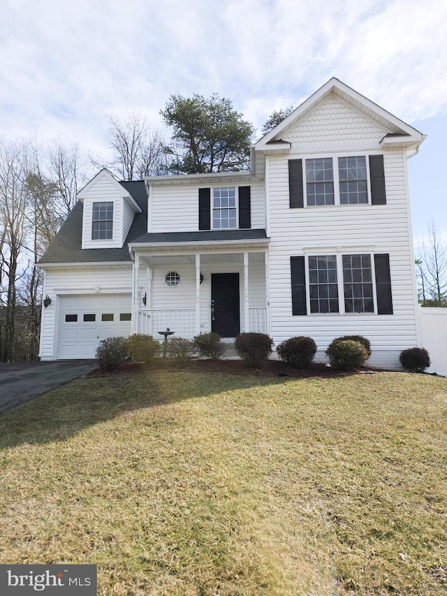 view of property with a porch, a garage, and a front yard