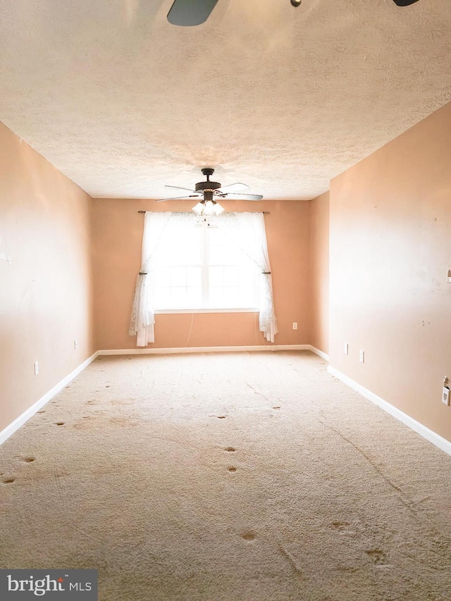 carpeted spare room with ceiling fan and a textured ceiling