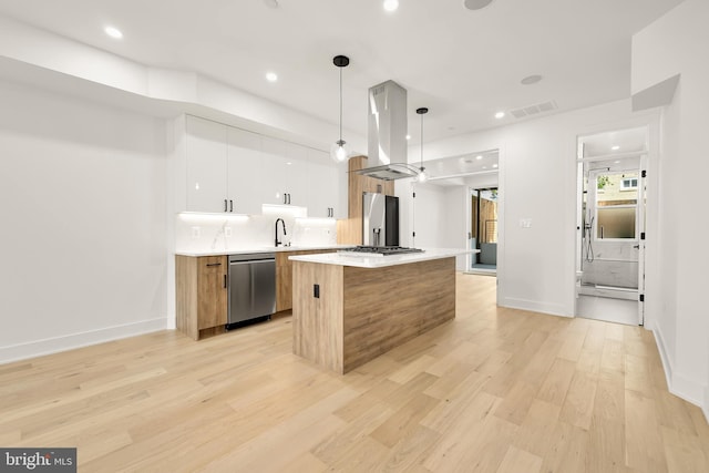 kitchen with white cabinetry, island exhaust hood, stainless steel appliances, decorative light fixtures, and a center island