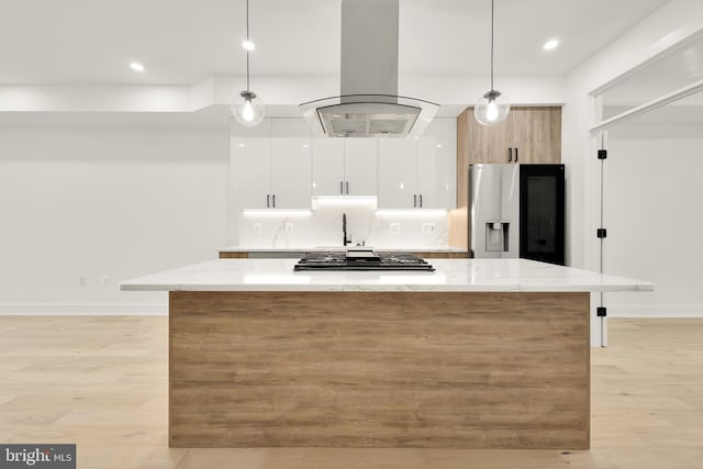 kitchen featuring light stone countertops, pendant lighting, white cabinets, and island exhaust hood