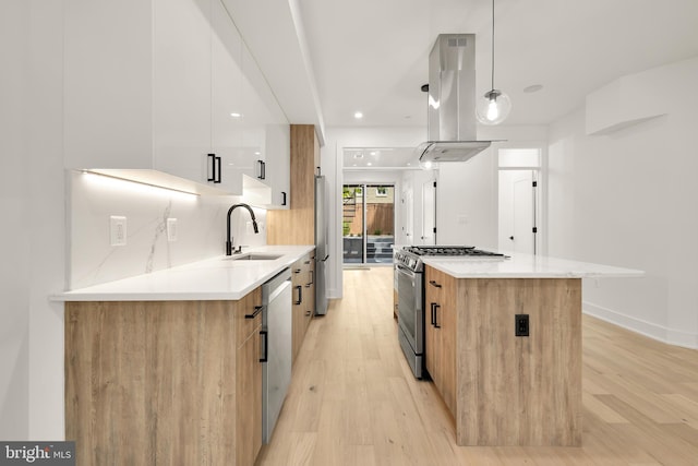 kitchen with pendant lighting, white cabinets, appliances with stainless steel finishes, sink, and island range hood