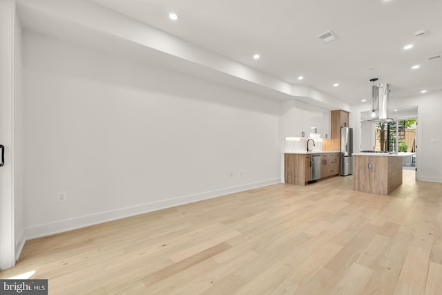 kitchen featuring a center island, decorative light fixtures, stainless steel appliances, island exhaust hood, and sink