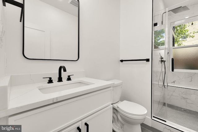 bathroom with a shower with shower door, toilet, and vanity