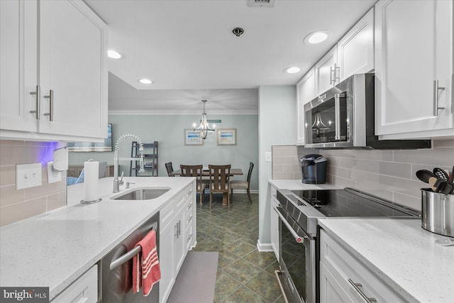 kitchen with sink, white cabinetry, light stone counters, and appliances with stainless steel finishes