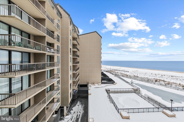 surrounding community with a water view and a view of the beach