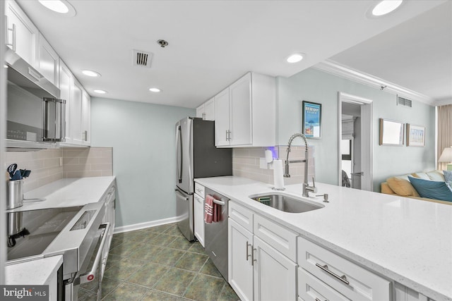 kitchen with sink, stainless steel appliances, white cabinets, and tasteful backsplash