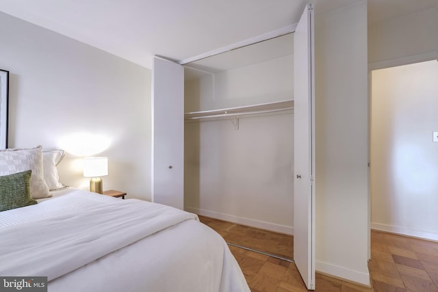 bedroom featuring parquet flooring and a closet