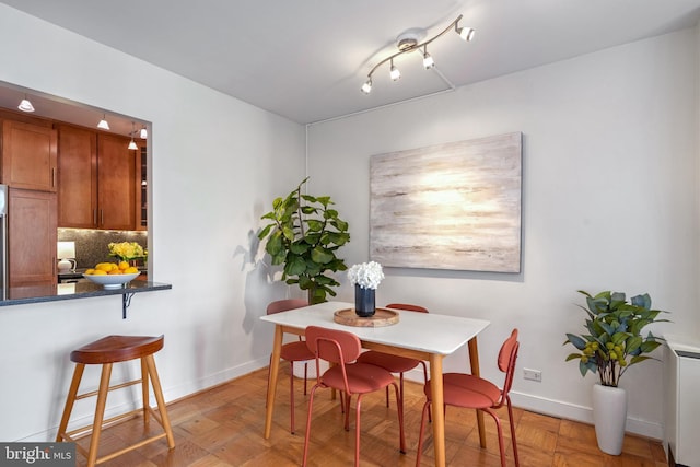 dining space with radiator heating unit and light parquet floors