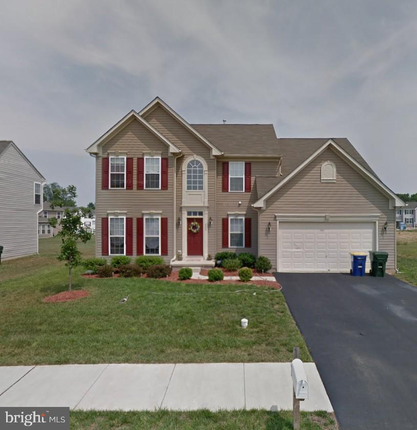 view of front of home with aphalt driveway, a front yard, and a garage