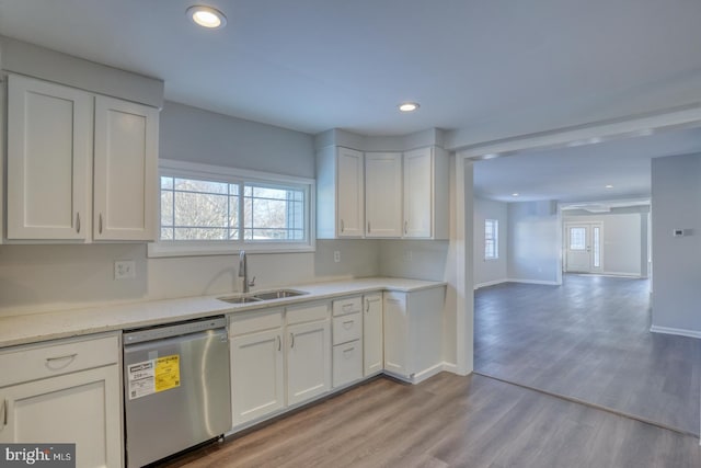 kitchen with white cabinetry, light wood-type flooring, dishwasher, a wealth of natural light, and sink