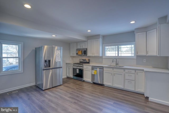 kitchen with white cabinets, appliances with stainless steel finishes, sink, and plenty of natural light