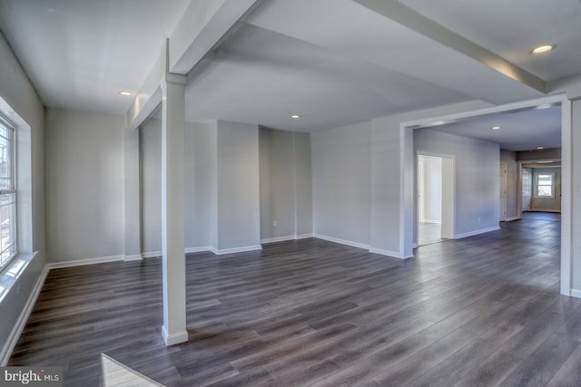 spare room featuring a healthy amount of sunlight and dark hardwood / wood-style floors