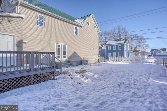 snow covered property featuring central AC and a deck