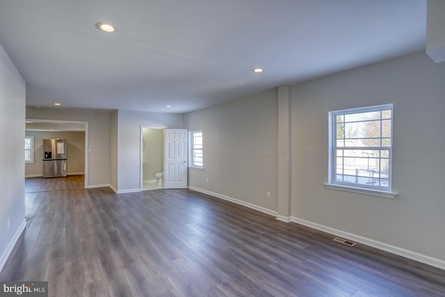 spare room featuring dark wood-type flooring and a wealth of natural light