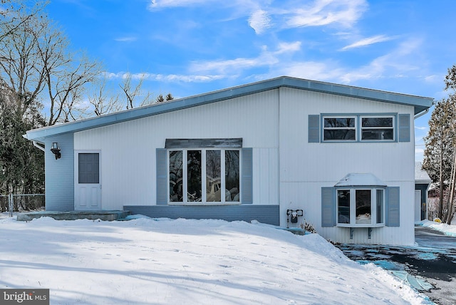 view of snow covered back of property