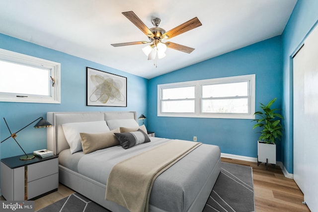 bedroom featuring light hardwood / wood-style floors, ceiling fan, and vaulted ceiling