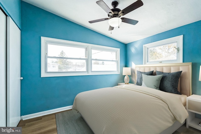 bedroom with ceiling fan, hardwood / wood-style floors, a closet, and lofted ceiling