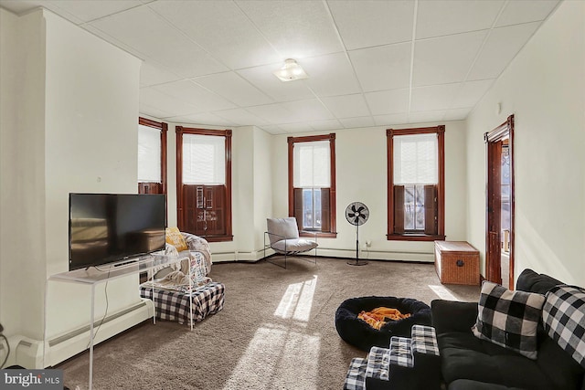 carpeted living room featuring a paneled ceiling, a baseboard heating unit, and a wealth of natural light