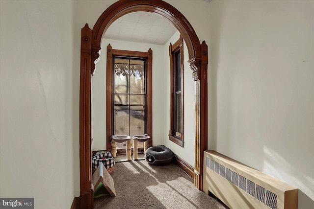 hallway featuring radiator and carpet flooring