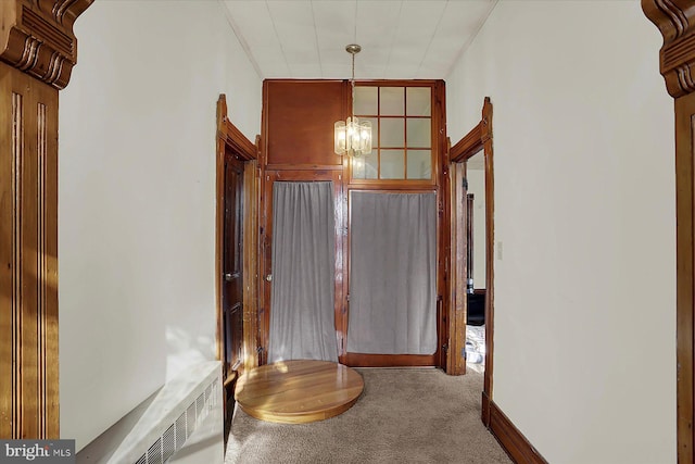 hallway featuring an inviting chandelier, carpet flooring, and radiator