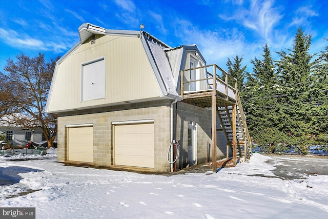 view of snowy exterior featuring a garage