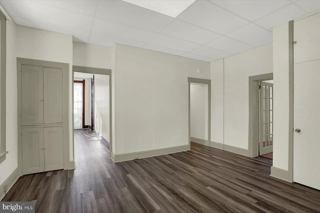 spare room featuring dark wood-type flooring and a paneled ceiling