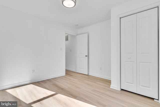 unfurnished bedroom featuring a closet and light hardwood / wood-style flooring