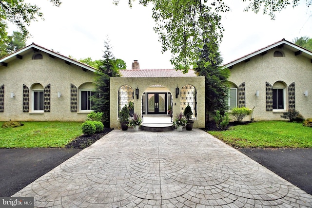 view of front of house with a front lawn and french doors