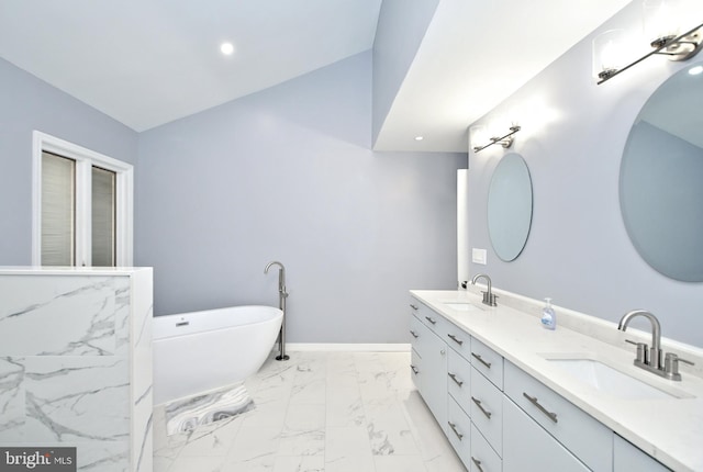 bathroom with vanity, a tub to relax in, and lofted ceiling