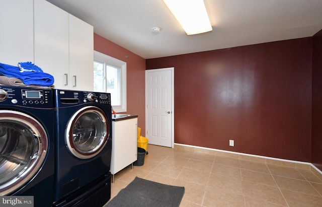 laundry area with washing machine and dryer, cabinets, and light tile patterned flooring