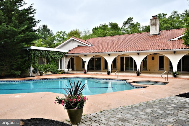 view of pool featuring a patio and an in ground hot tub