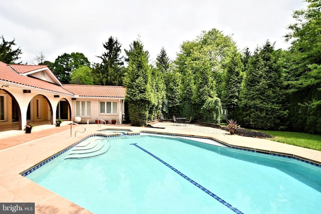 view of pool with a patio area and an in ground hot tub