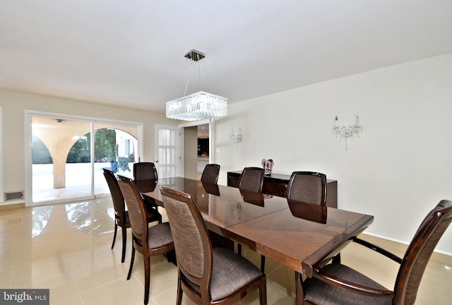 dining area with a chandelier and light tile patterned floors