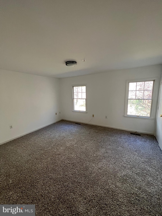 carpeted spare room featuring plenty of natural light