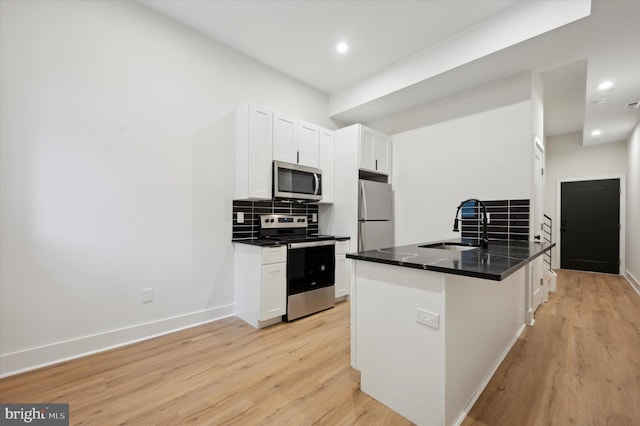 kitchen with stainless steel appliances, light hardwood / wood-style floors, white cabinets, and sink