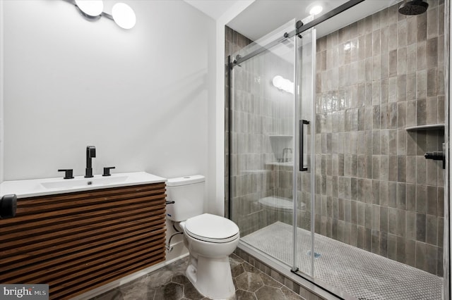 bathroom featuring toilet, a shower with door, and sink