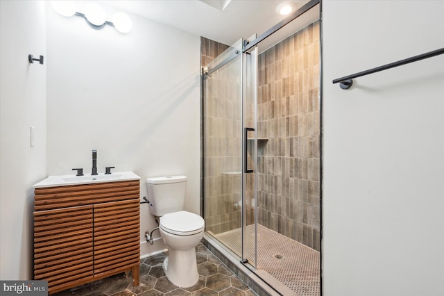 bathroom with toilet, a shower with shower door, and vanity